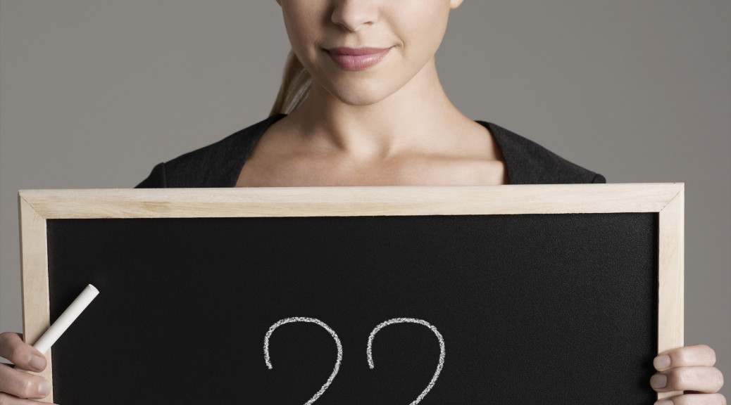 Portrait of young businesswoman holding blackboard with question marks
